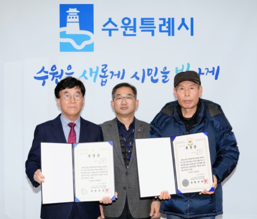 홍건표 수원시 복지여성국장(가운데)이 화랑무공훈장을 전수받은 유족들과 함께하고 있다.