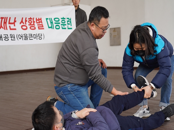 인천시사회서비스원이 최근 인천대공원 어울큰마당에서 마련한‘재난난상황별 대응훈련’에 참여한 직원들이 강사의 안내를 받아 위급 상황 시 환자 이송방법을 체험하고 있다.