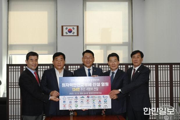 ‘원자력안전교부세 신설 촉구 134만 주민 서명부’전달식이 8일 국회 행정안전위원장실에서 김영길 전국원전인근지역 동맹 행정협의회 회장(울산 중구청장)과 권익현·김재윤 전국원전인근지역 동맹 행정협의회 공동부회장 (전북 부안군수·부산 금정구청장), 박성민 국회의원 등이 참석한 가운데 열렸다. 김영길 전국원전인근지역 동맹 행정협의회 회장 등은 김교흥 국회 행정안전위원장에게 서명부를 건넨 뒤 기념촬영을 하고 있다.