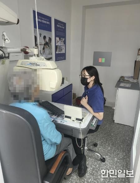 어르신이 안경원에서 시력 검사를 하고 있다