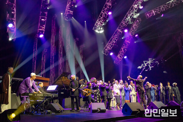 Musical Director John Beasley conducting the 2025 International Jazz Day All-Star Global Concert hosted by Jeremy Irons at Etihad Arena on April 30th in Abu Dhabi, UAE with (from L to R) Danilo Pérez, Herbie Hancock, Hélène Mercier, Rhani Krija, Naseer Shamma, Dianne Reeves, Janis Siegel, Ruthie Foster, Linda May Han Oh, Marcus Miller, Tomoaki Baba, Dee Dee Bridgewater, Kurt Elling, Varijashree Venugopal, José James, John McLaughlin, Nils Landgren, Arturo Sandoval and other all-star artists.