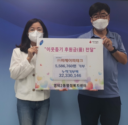 영덕2동에 성금을 기탁한 피제이피테크 관계자가 기념촬영을 하고 있다.