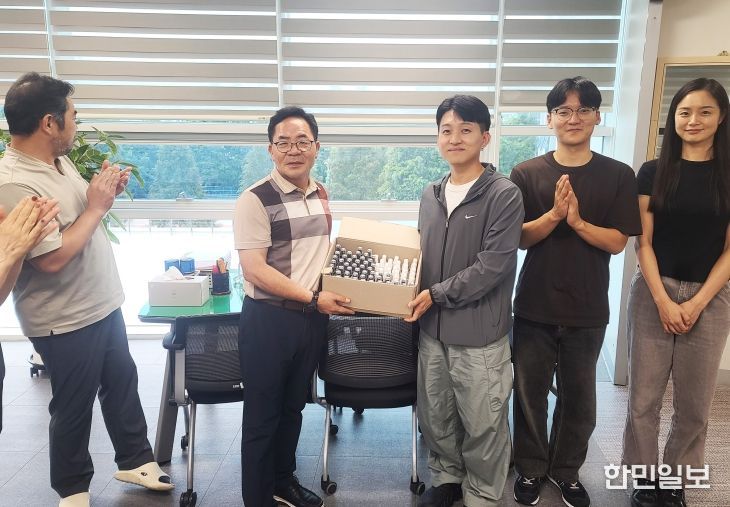 경상국립대학교 약학대학 생약동아리 ‘심마니’ 회원들이 행정지원과 성문기 과장에게 학생들이 만든 아로마 스프레이를 전달하고 있다.