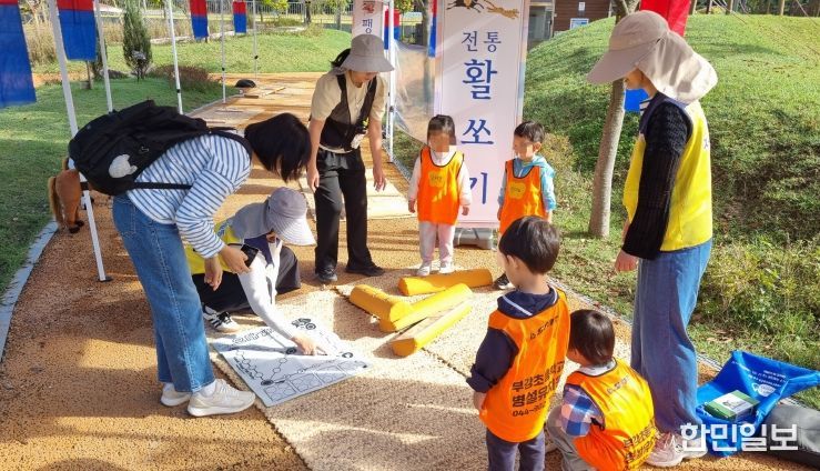 23일 무지개 축제에서 아이들이 활쏘기 체험과 멧돌을 체험해 보고 있는 모습