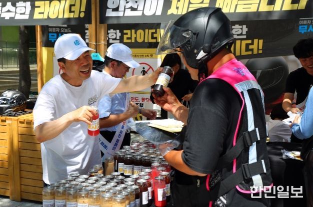 근로복지공단 박종길 이사장(왼쪽)이 지난 7월 서울 역삼역 인근에서 배달라이더들에게 시원한 음료를 나누어 주면서 고용·산재보험 거리 홍보를 진행했다.