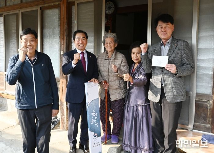 성낙인 창녕군수가 창녕읍 섬마길에 거주하고 계신 100세 어르신에게 청려장과 대통령 축하 서한을 전달하고 있다.