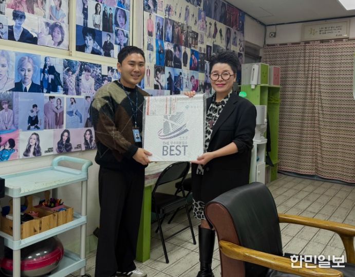 군 관계자가 공중위생서비스 평가 우수업소에 현판을 건네고 있다