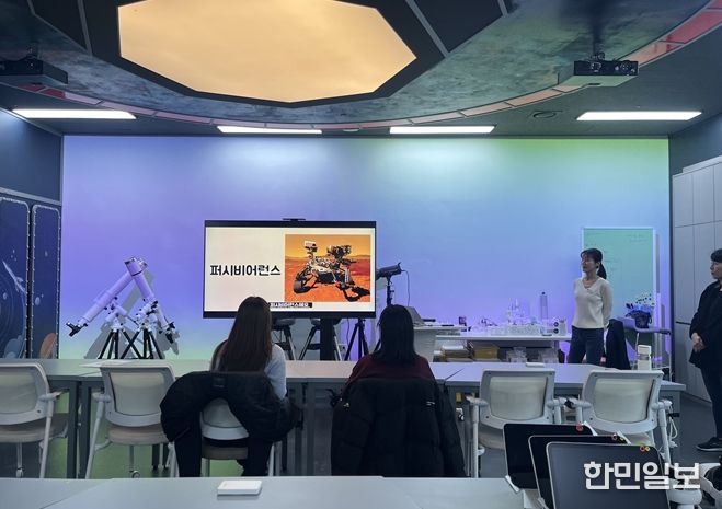 우주탐사실에서 행성 탐사 로버에 대해 교육 받는 장면
