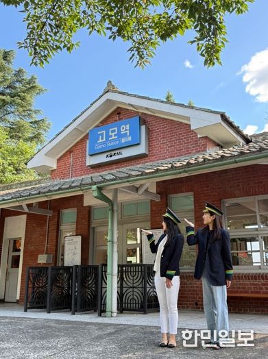 관광객들이 고모역에서 역무원 체험을 하고 있다.