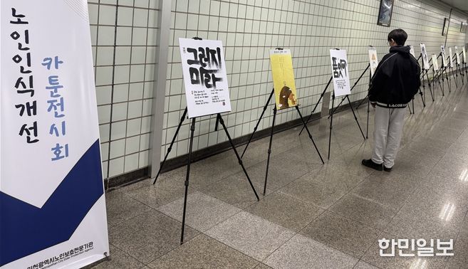 인천지하철 1호선 동춘역을 지나는 한 학생이 인천시노인보호전문기관 ‘노인인식개선 카툰전시회’ 작품을 읽고 있다.