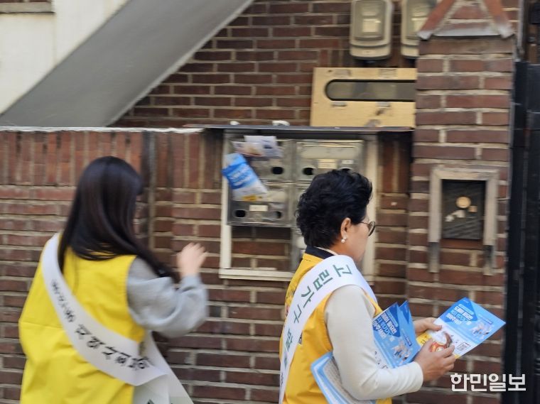 동선동지역사회보장협의체 위원들이 고립 위험가구 발굴을 위한 현장캠페인을 진행하며 안내문을 부착하고 있다.