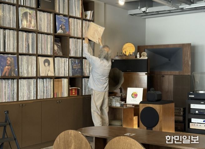 음악감상실 온 주인장이 신청곡 LP를 찾고 있다.